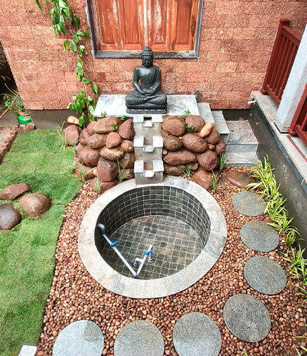 Custom stone plunge pool with cascading water feature and Buddha sculpture